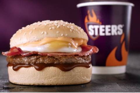 Halaal breakfast burger with fried egg and beef patty next to a Steers takeaway cup