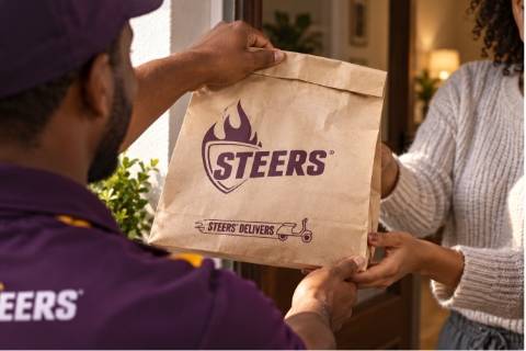 Steers delivery driver handing a Steers breakfast delivery bag to a customer at her front door