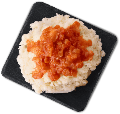 Pap topped with chunky tomato sishebo served on a black square plate