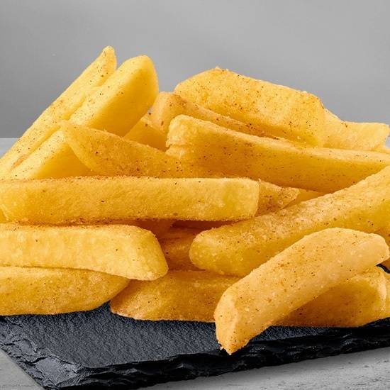 Close-up of crispy seasoned chips stacked on a black slate tray